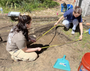 UM students using tape measures to map an excavation unit