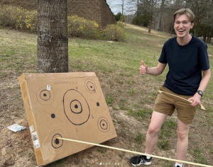 Student celebrating hitting the target after throwing his spear using an atl-atl.