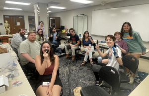 Students smiling for camera at a stone tool making activity